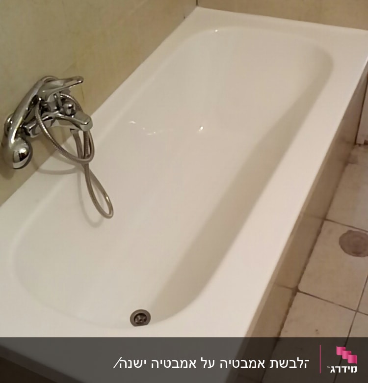 אמבטיה לבנה עם ברז כרום על קיר אריחים